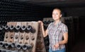 Young woman in cellar with wine bottles storage Royalty Free Stock Photo