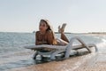 Young woman in chaise lounge at the sea beach. Girl relax on beach