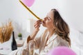 Young woman with champagne blowing party