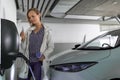 Young woman charging an electric vehicle