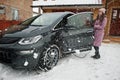 Young woman charging her electric car in winter Royalty Free Stock Photo