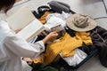 Young woman check baggage lists on notebook to prepare for traveling trip