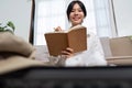 Young woman check baggage lists on notebook to prepare for traveling trip