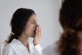 Young woman check freshness of breath in home bath