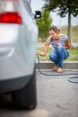 Young woman checking the car tyre pressure Royalty Free Stock Photo