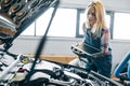 Young woman checking fuel economy, car timing, and performance characteristics.