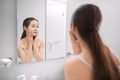 Young woman checking her face in mirror in morning Royalty Free Stock Photo