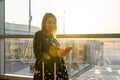 A young woman, checking her mobile phone, is prepared for boarding. Royalty Free Stock Photo