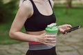 A young woman checking her progress on a smartphone. Fitness sporty girl holding a bottle of water Royalty Free Stock Photo