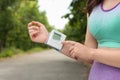 Young checking pulse with medical device after training in park, closeup