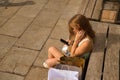 Young woman checking social networks on her cell phone sitting on a bench surrounded by shopping bags seen from above Royalty Free Stock Photo