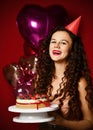 Young woman chef cook holding sweet cake with strawberry blueberry and cream smiling on dark red background Royalty Free Stock Photo