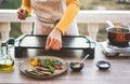 Young woman chef cooking outdoor while streaming online for webinar masterclass lesson at home during isolation quarantine - Food