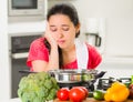 Young woman chef cooking with skeptical facial expressions, interacting frustrated body language Royalty Free Stock Photo