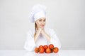 Young woman chef showing tomatos for italian food on white Royalty Free Stock Photo