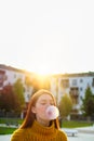 Young Woman Chewing Gum And Making Big Balloon