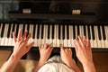 Young woman with child playing piano, above view. Music lesson Royalty Free Stock Photo