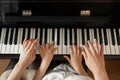 Young woman with child playing piano. Music lesson Royalty Free Stock Photo