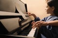 Young woman with child playing piano. Music lesson Royalty Free Stock Photo