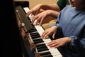 Young woman with child playing piano, closeup. Music lesson Royalty Free Stock Photo