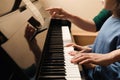 Young woman with child playing piano. Music lesson Royalty Free Stock Photo