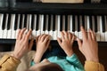 Young woman with child playing piano. Music lesson Royalty Free Stock Photo