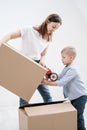 A young woman and a child stick cardboard boxes with a dispenser and adhesive tape. Royalty Free Stock Photo