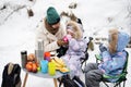 Young woman with children in winter forest on a picnic. Mother and two daughters Royalty Free Stock Photo