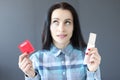 Young woman chooses between birth control pills and condom Royalty Free Stock Photo