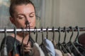 A young woman chooses clothes on hangers during shopping Royalty Free Stock Photo