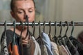 A young woman chooses clothes on hangers during shopping Royalty Free Stock Photo