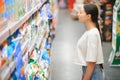 A young woman chooses household chemicals in a supermarket. Means for washing and cleaning the house Royalty Free Stock Photo