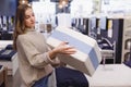 Young woman chooses mattress and bed in furniture showroom store Royalty Free Stock Photo