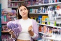 Young woman chooses set of gifts for someone in cosmetics store