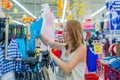 Young woman chooses shirt in shop Royalty Free Stock Photo