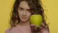 Young woman choosing apple instead cake for diet nutrition in studio Royalty Free Stock Photo