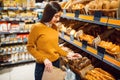 Young woman choosing bread in grocery store Royalty Free Stock Photo