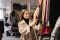 Young woman choosing clothes in clothes store