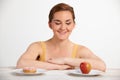 Young Woman Choosing Between Doughnut And Cake For Snack Royalty Free Stock Photo