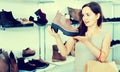 Young woman choosing fall boots in shoes store Royalty Free Stock Photo