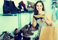 Young woman choosing fall boots in shoes store Royalty Free Stock Photo