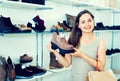 Young woman choosing fall boots in shoes store Royalty Free Stock Photo