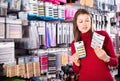 Young woman is choosing new hair clips in hair care store. Royalty Free Stock Photo