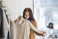 Young woman choosing sweater in store