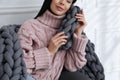 Young woman with chunky knit blanket on sofa at home, closeup Royalty Free Stock Photo