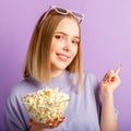 Young woman in cinema glasses watching 3d movie. Smiling teenager girl movie viewer in glasses with popcorn show side by Royalty Free Stock Photo