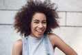 Young woman in the city street standing on gray wall looking camera laughing cheerful close-up Royalty Free Stock Photo