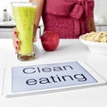 Young woman and clean eating: oatmeal cereal, apple and smoothie