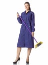 A young woman-cleaner stands with a broom in a blue robe. Royalty Free Stock Photo