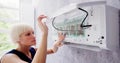 Young Woman Cleaning Air Conditioning System Royalty Free Stock Photo